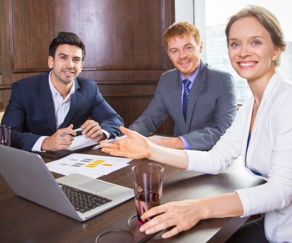 business-woman-sitting-with-two-men-suit-smiling(1)